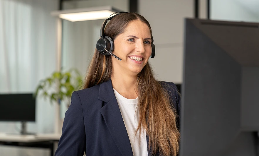 Eine Servicemitarbeiterin mit Headset um Online-Beratungen durchzuführen.