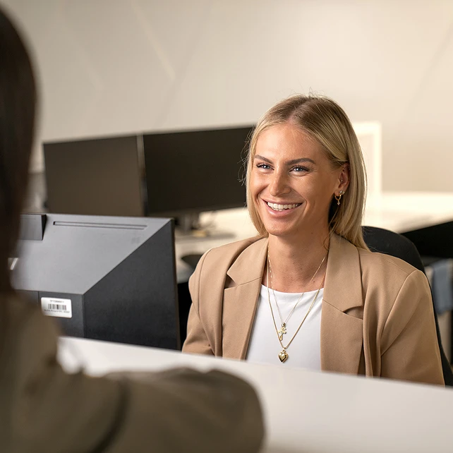 Freundliche Empfangsdame begrüßt Kunden.