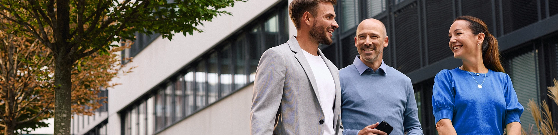 Drei Mitarbeiter der Schwarz Corporate Solutions unterhalten sich auf dem Weg zur Arbeit.